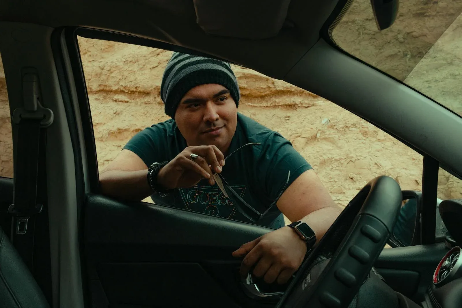 Man standing next to driver's seat of a car