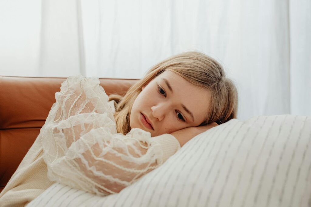 Sad teenager lying on pillow