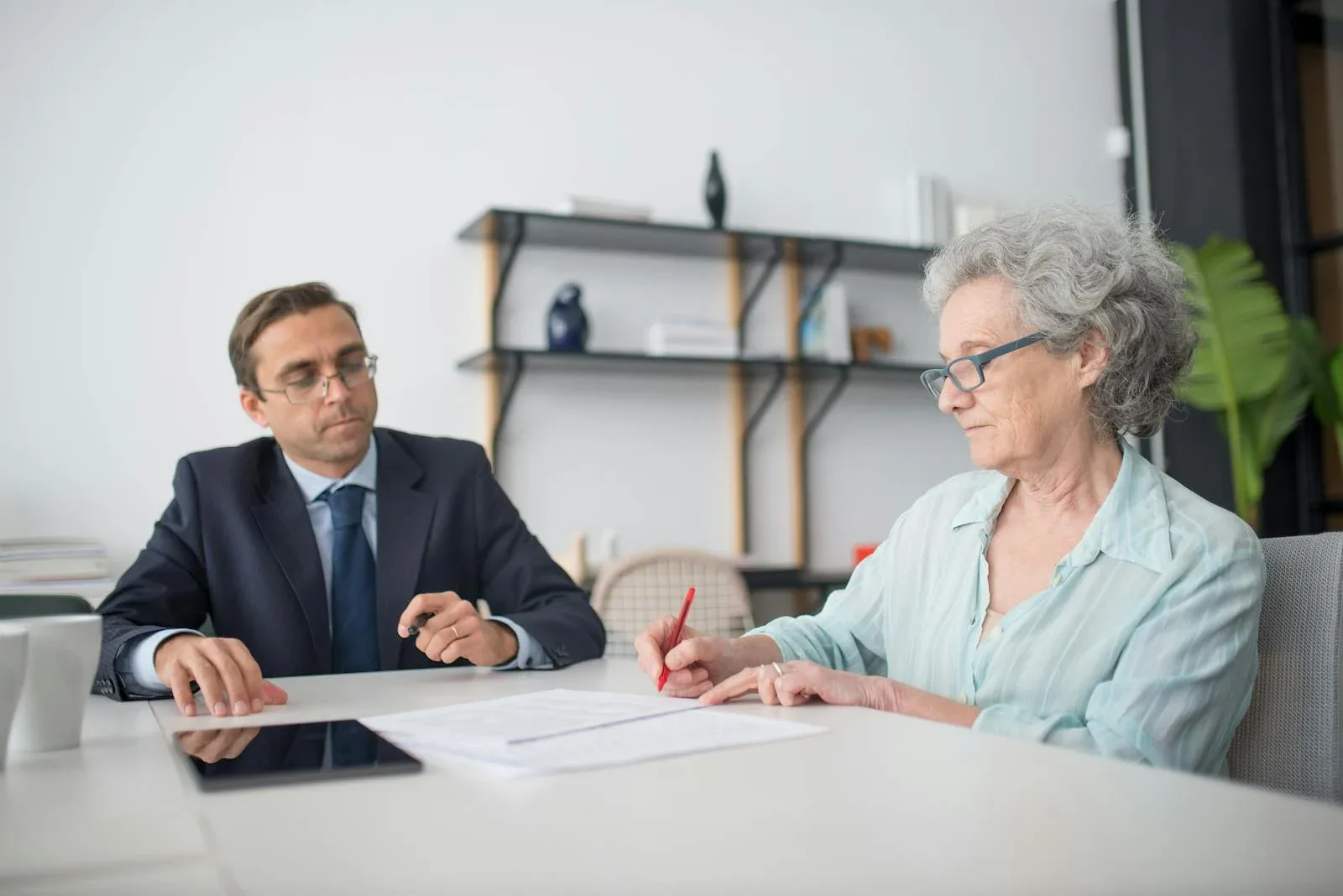 Elderly woman completing the title transfer form