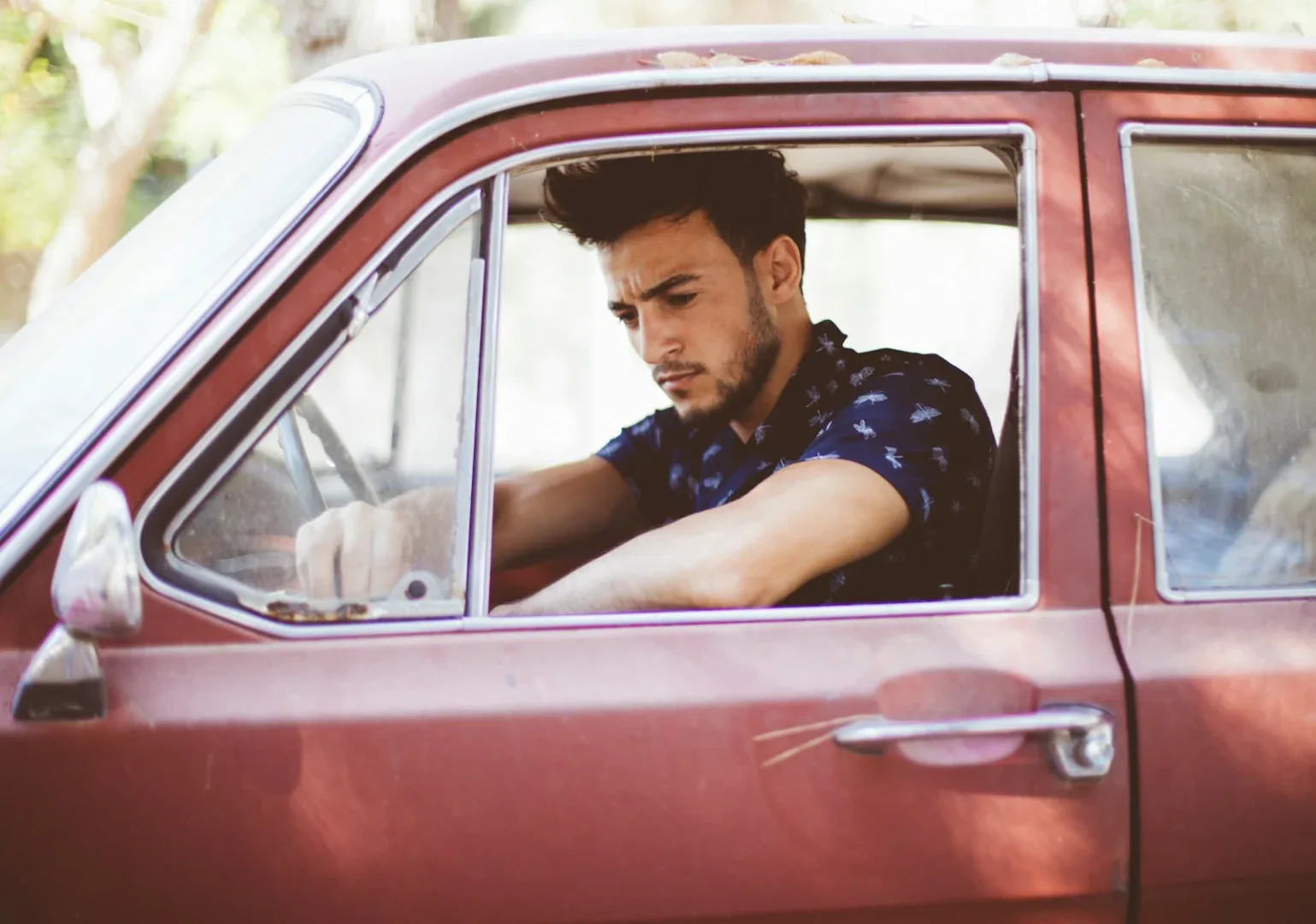 man driving red car